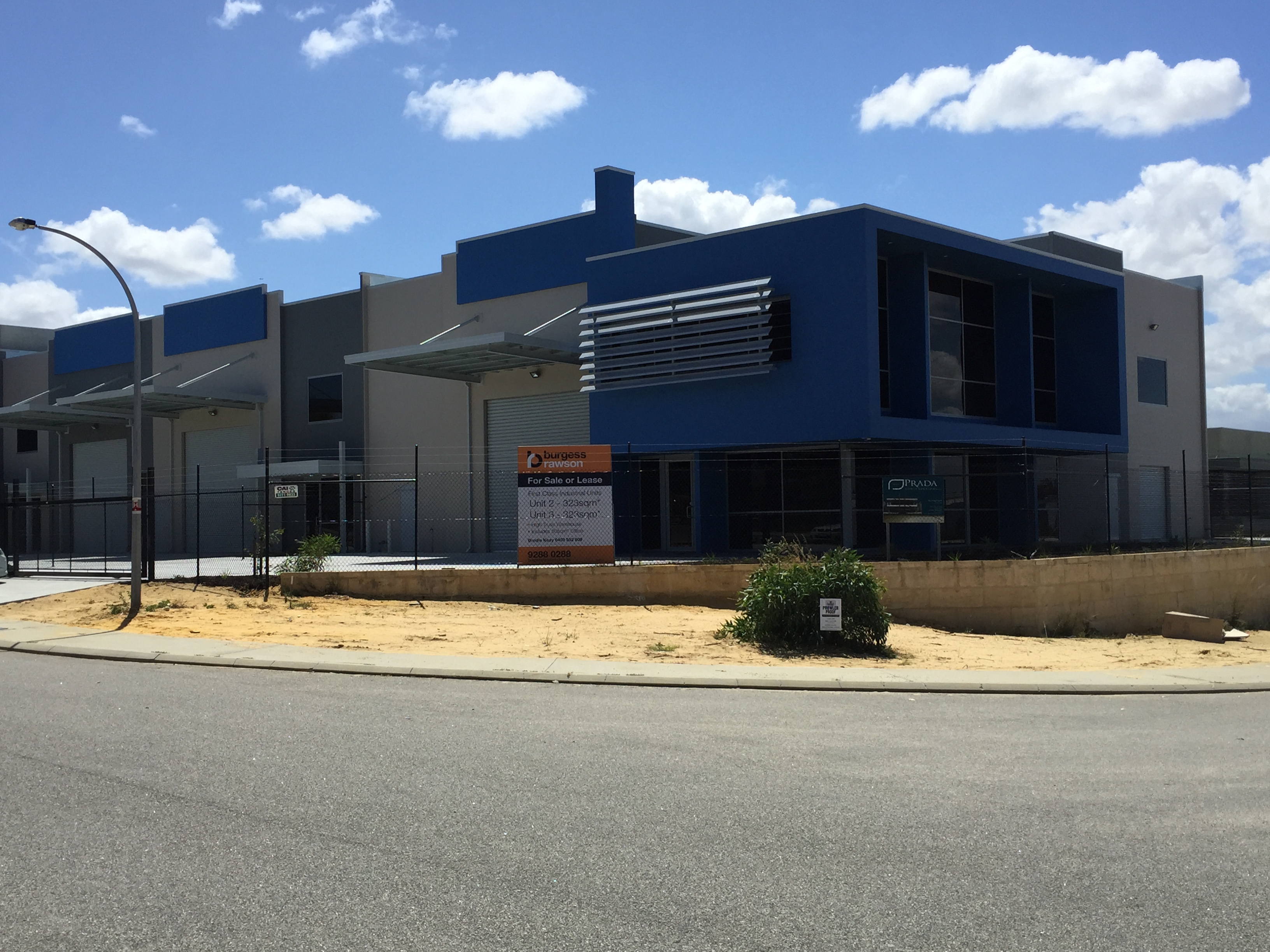 Exterior shot of commercial warehouse office unit, painted in dark blue and grey tones