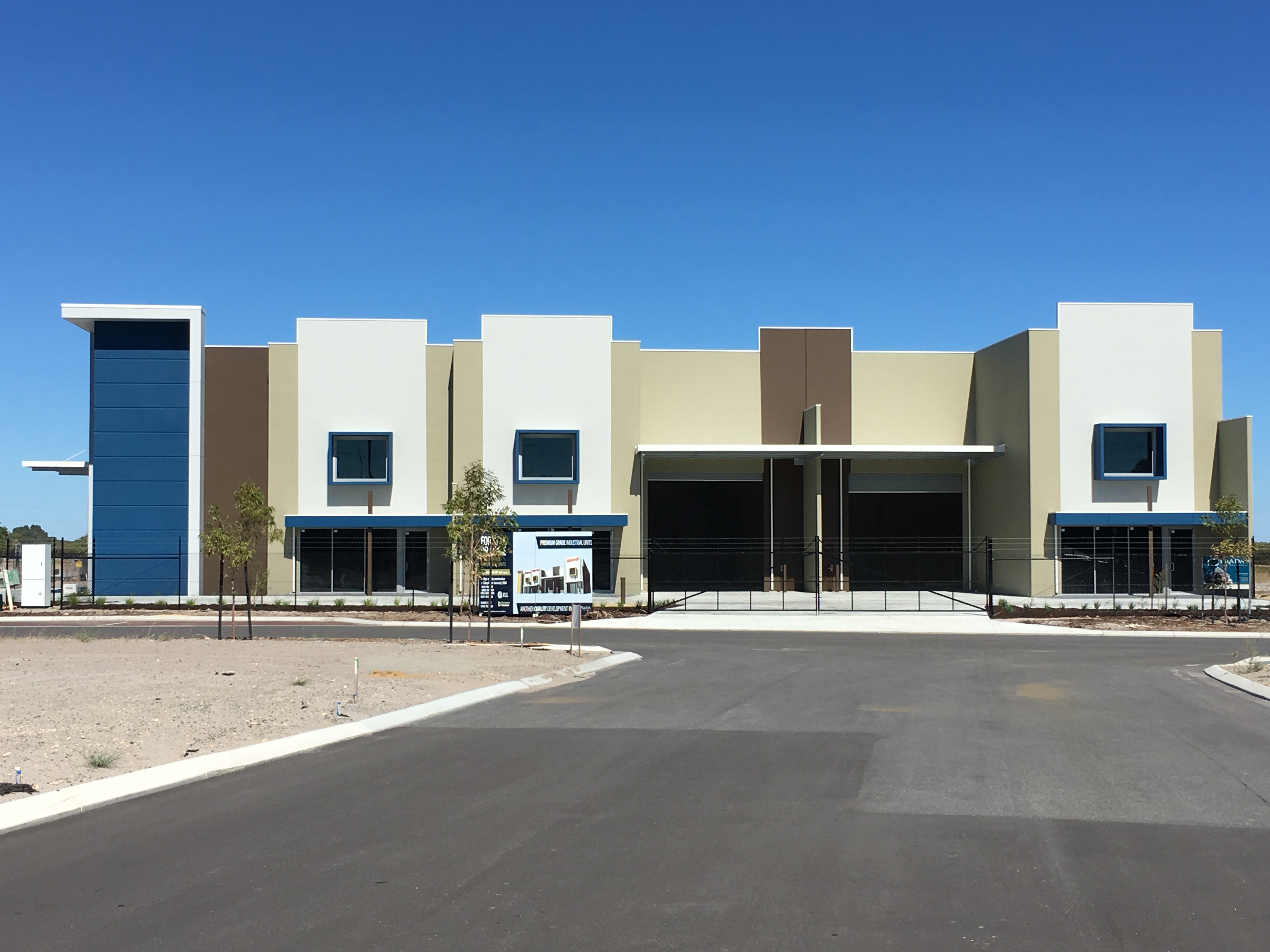 Exterior shot of commercial warehouse unit, painted in tones of blue, brown, cream and white