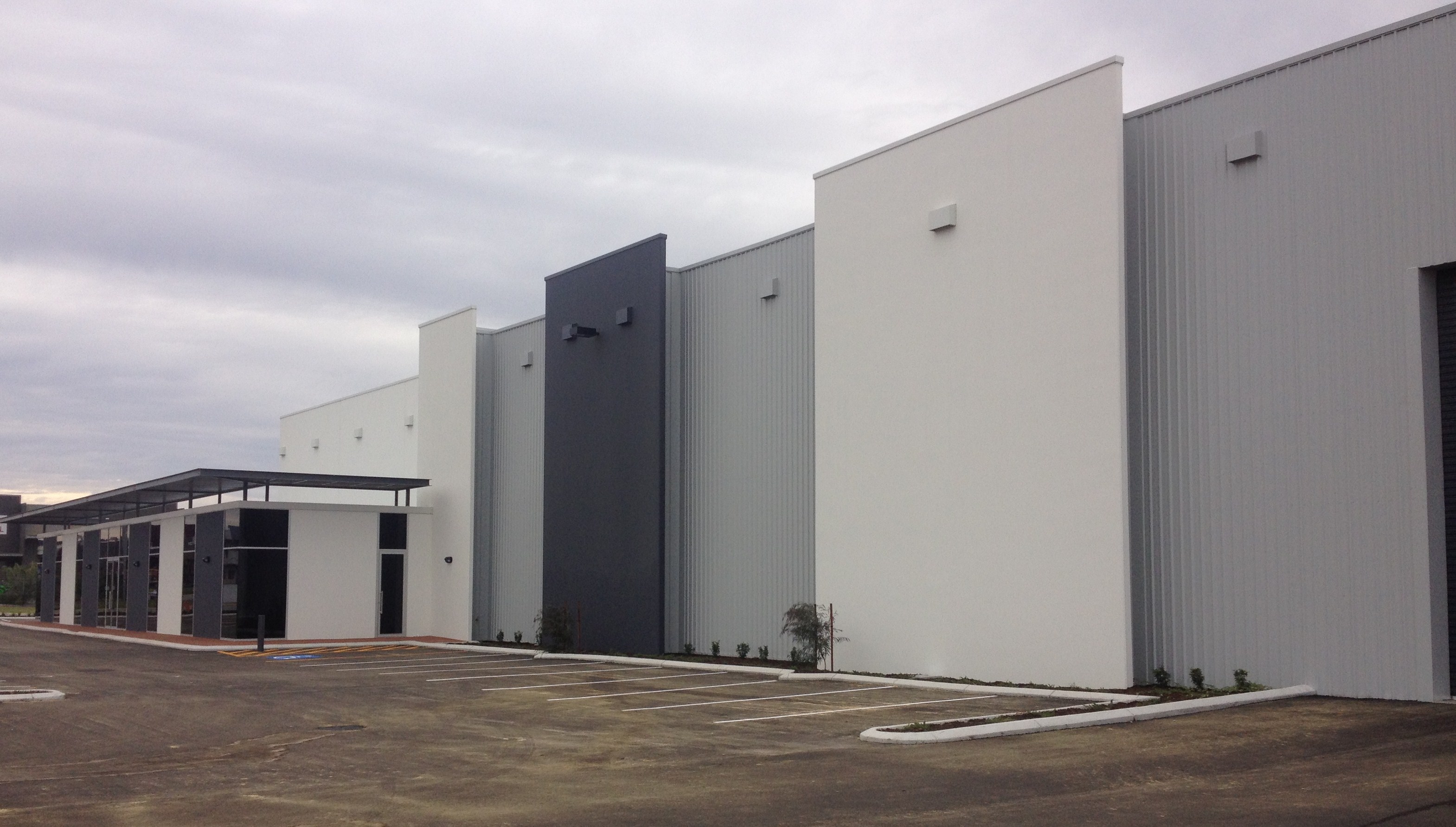 Exterior of large scale warehouse unit, painted in shades of grey