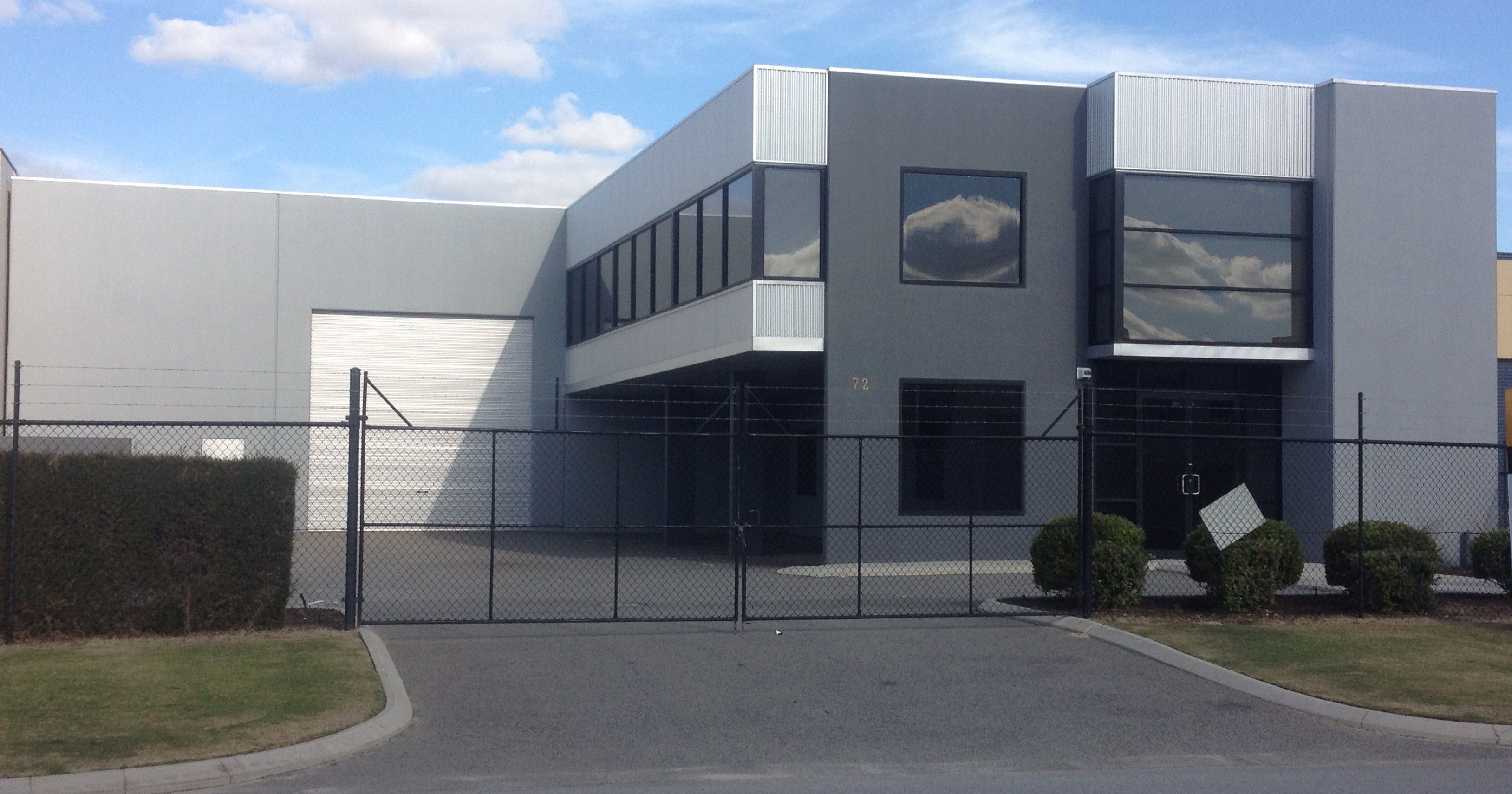 Exterior of modern warehouse/office unit, finished in shades of grey