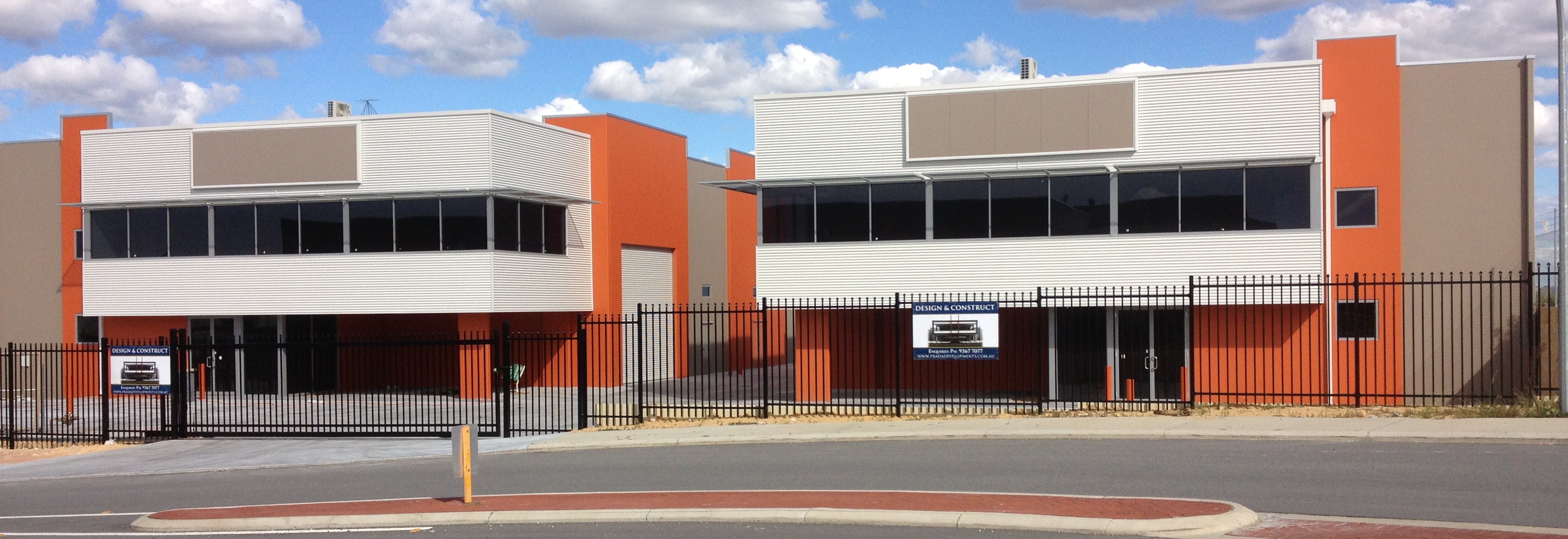 Exterior shot of twin warehouse office units, finished in white and orange paint