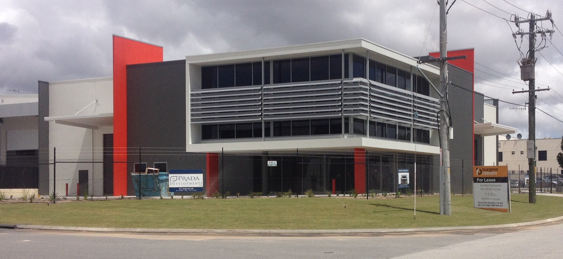 Exterior of commercial office building, finished in dark grey and red paint